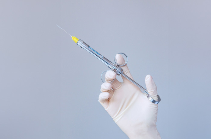 歯科麻酔用の注射器を持つ手