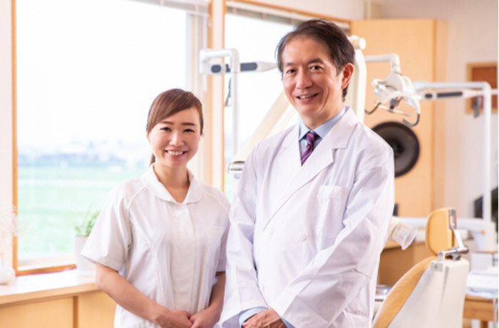 笑顔でこちらを見ている歯科医師と歯科衛生士
