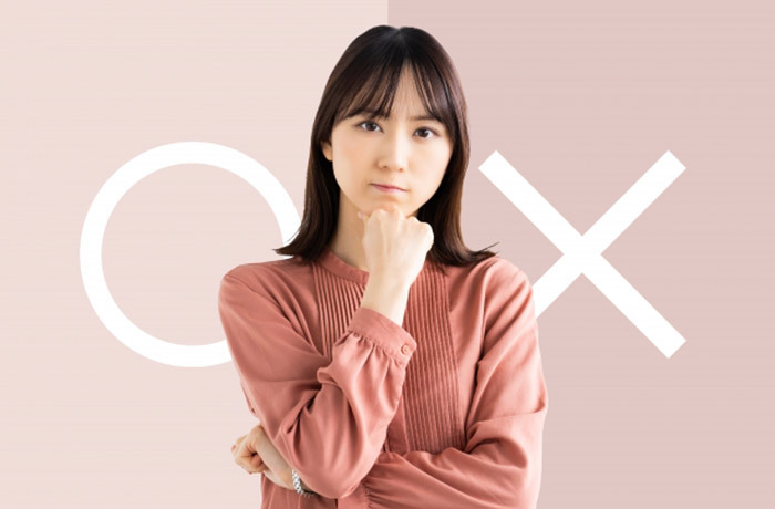 ○と×が書かれた背景に、顎に手を当て悩む女性