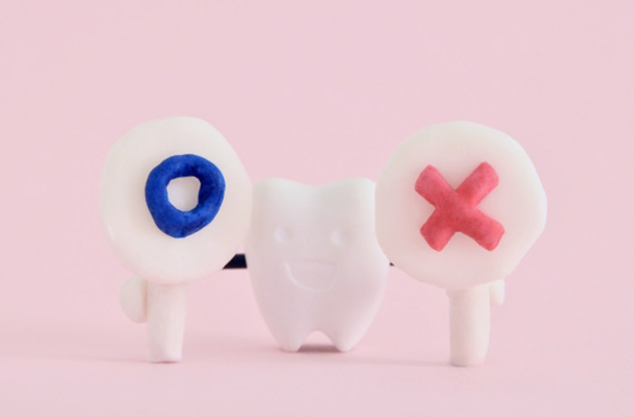 歯のキャラクターが両手にそれぞれ丸とバツの札を持っている可愛い画像