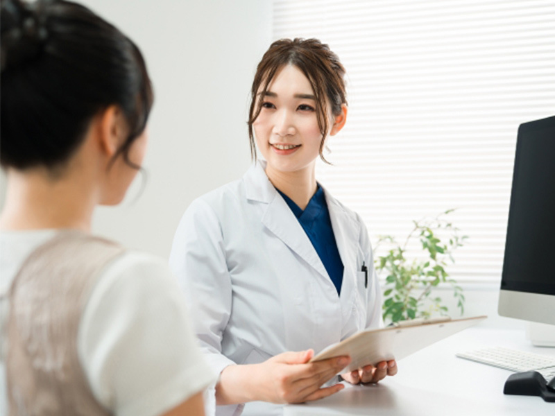 日常生活での開口制限の指導をする歯科医師と、話を聞く患者さんの画像