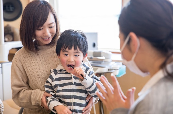 歯科衛生士と一緒に歯みがき練習をする子ども