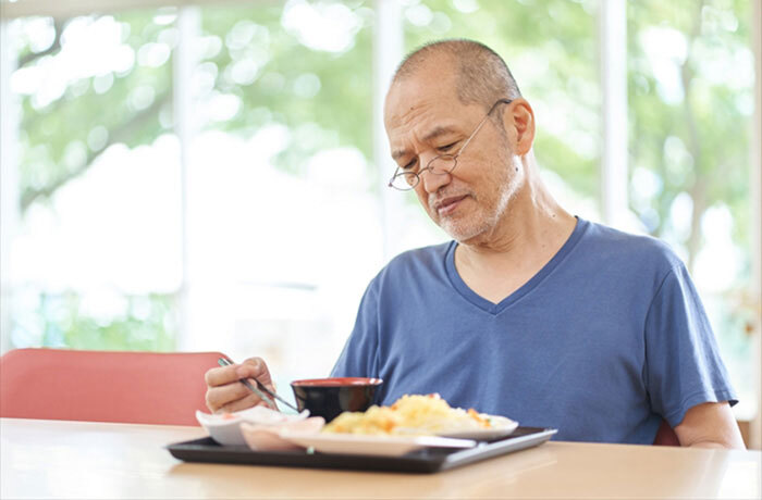 食事中に硬いものが噛みにくくなったと感じ落ち込む高齢男性