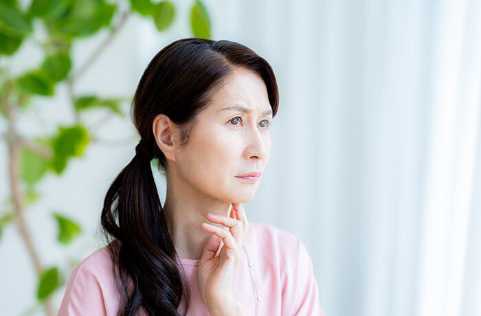 噛む、飲み込む、話すといった口のさまざまな機能の衰えに悩むシニア女性