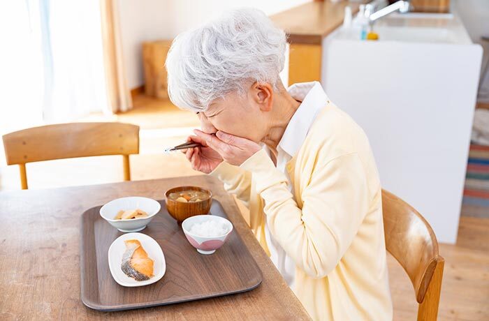 食事中、お味噌汁を飲んでむせてしまった高齢女性